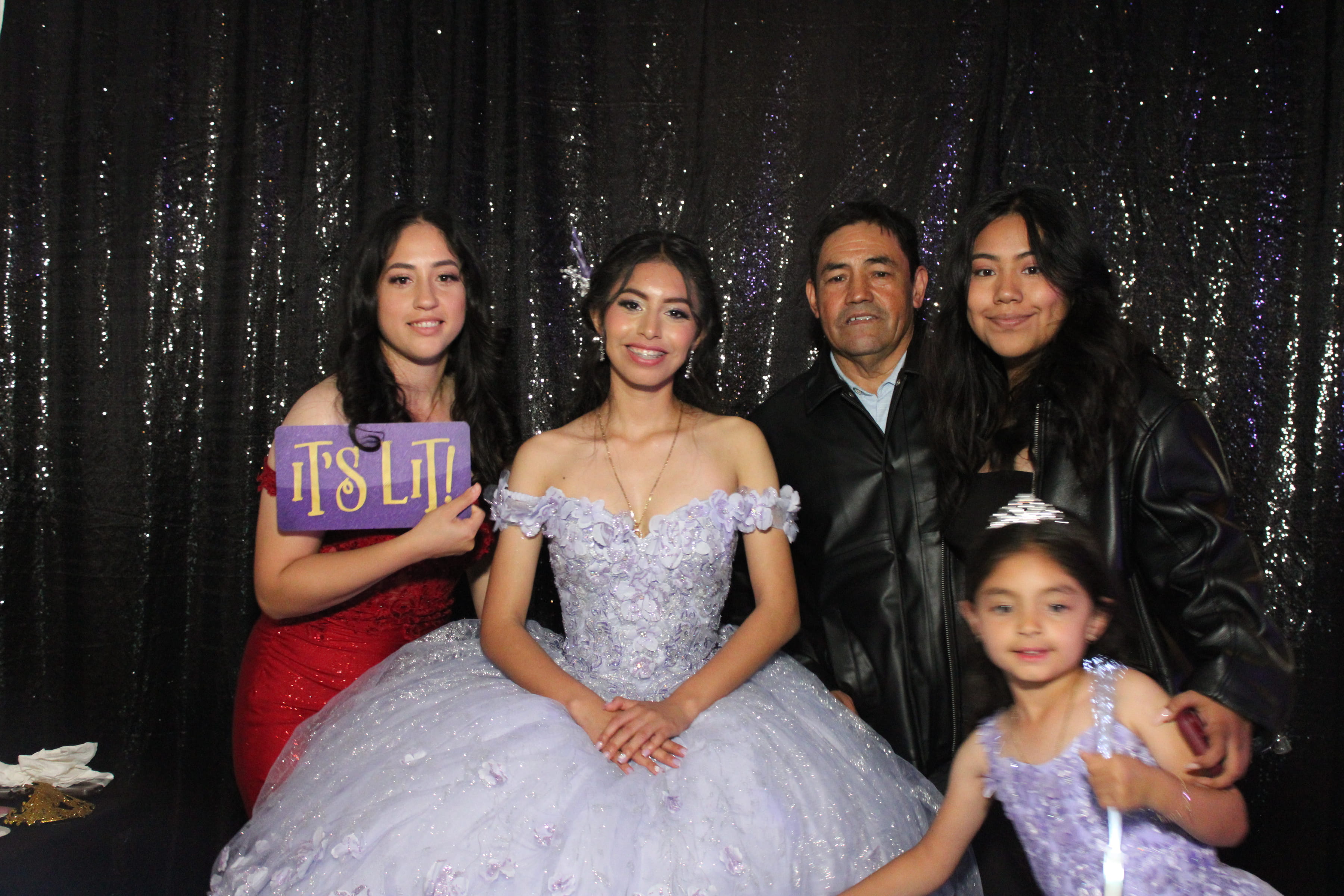 Quinceañera family portrait at the Allure Mirror Booth — lavender gown, sequin backdrop, 'It's Lit' sign